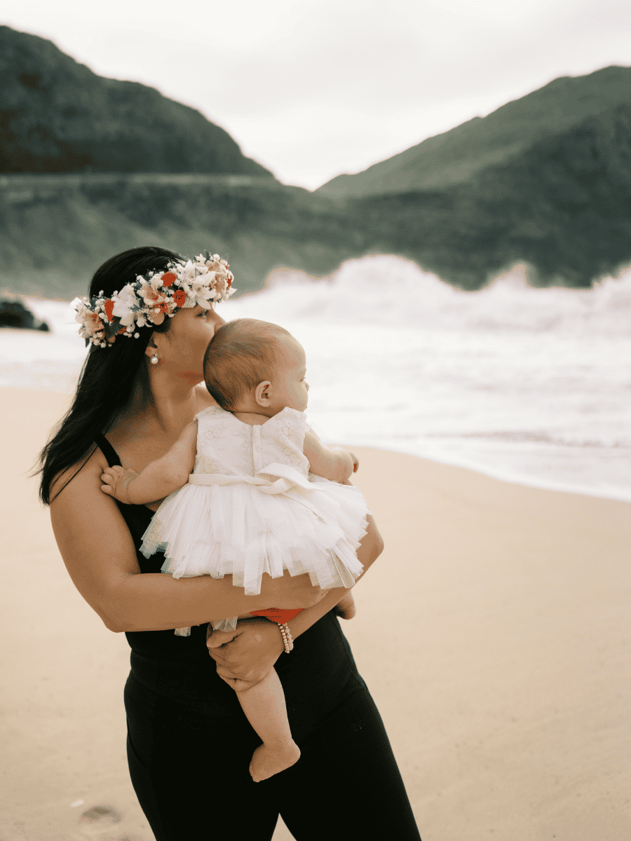 Diana Bejasa holding her daughter on a beach in Hawai‘i for her About page.