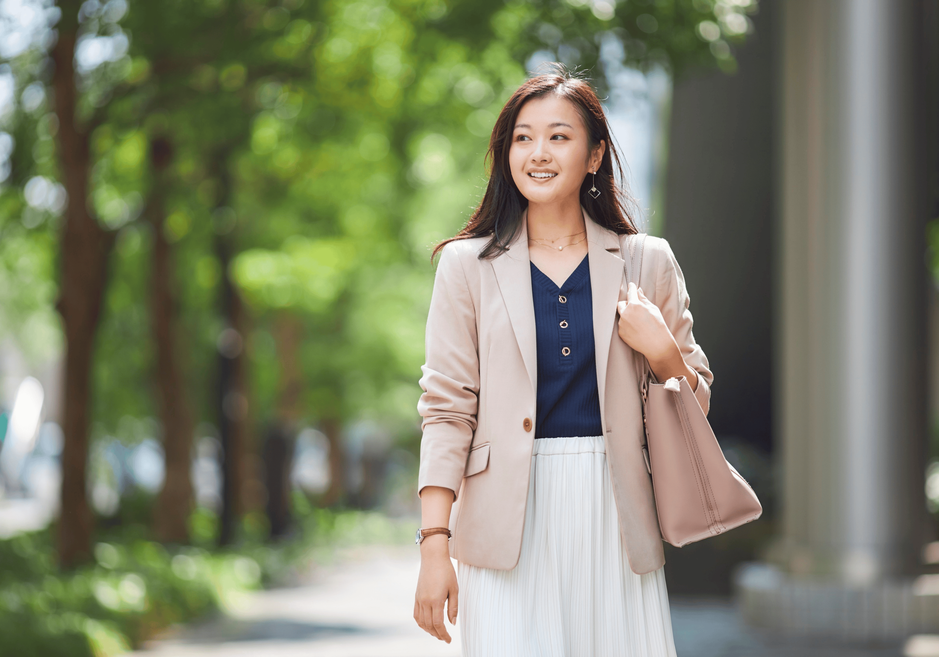 A confident professional woman walking forward outdoors, symbolizing renewed clarity, capacity, and balanced ambition.