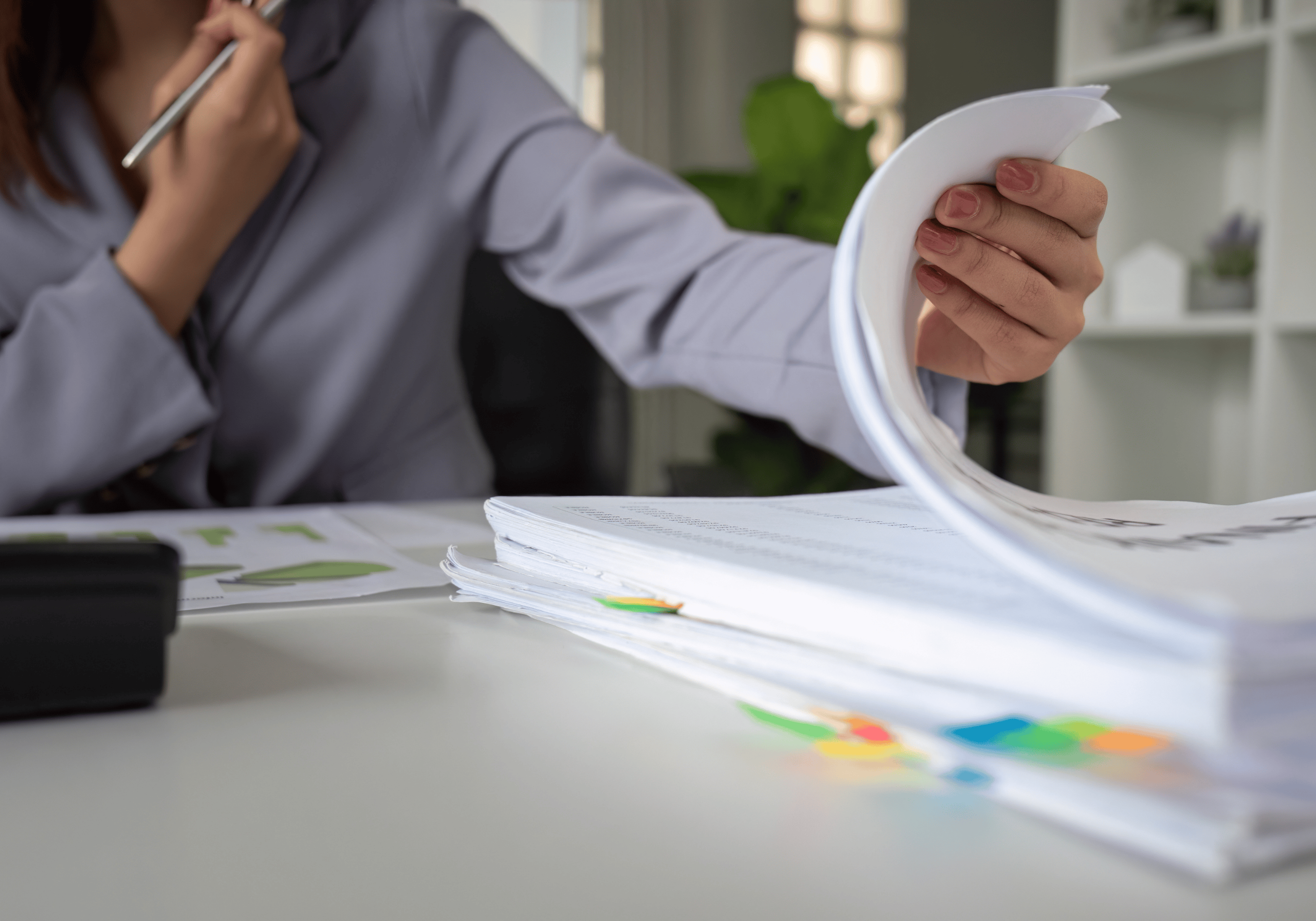 A calm professional woman thoughtfully reviewing notes at her desk, symbolizing the moment high achievers recognize that capacity—not stress—is the real key to sustainable success.